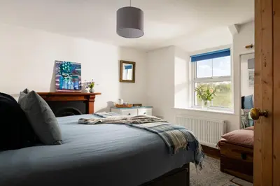 a bedroom with a bed and a window at 1 Rock Cottages in Treknow