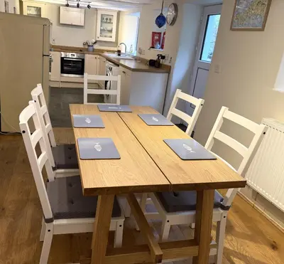 a wooden table with laptops on top of it in a kitchen at 1 Rock Cottages in Treknow