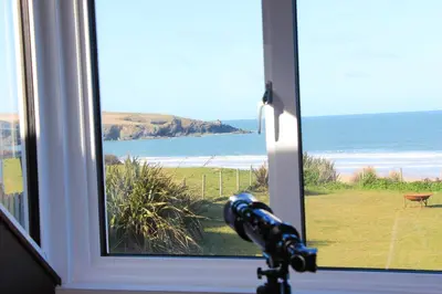 a window with a view of the ocean at ON THE BEACH holiday home in St Merryn