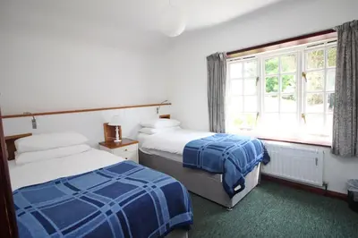 a bedroom with two beds and a window at ON THE BEACH holiday home in St Merryn