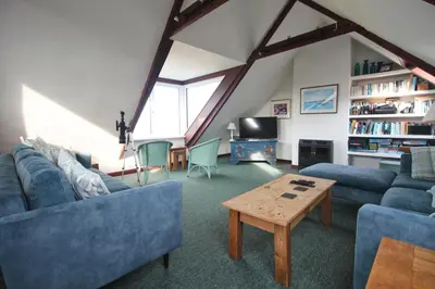a living room with blue couches and a table at ON THE BEACH holiday home in St Merryn