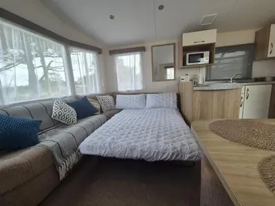 a living room with a couch and a table at Cosy Perranporth caravan, Cornwall in Perranzabuloe