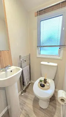 a bathroom with a white toilet and a sink at Cornwall Caravan Retreat 3 Crantock in Crantock