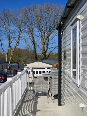 a deck with two chairs and a table on a house at Cornwall Caravan Retreat 3 Crantock in Crantock