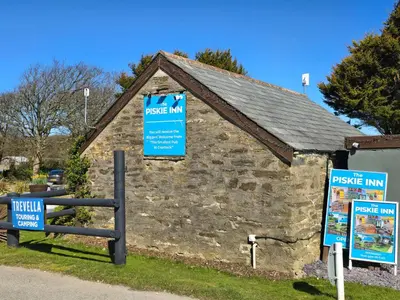 a stone building with signs on the side of it at Cornwall Caravan Retreat 3 Crantock in Crantock