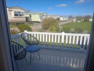 a balcony with a chair and a table on a deck at St Merryn in St Merryn