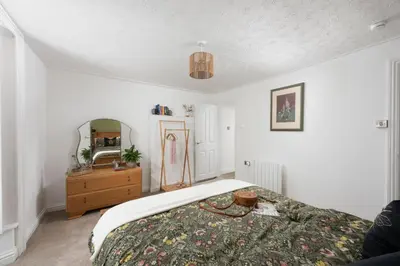 a bedroom with a bed and a dresser and a mirror at City Centre 1 bed Georgian flat with courtyard in Truro