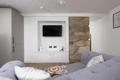 a living room with a blue couch and a tv at City Centre 1 bed Georgian flat with courtyard in Truro