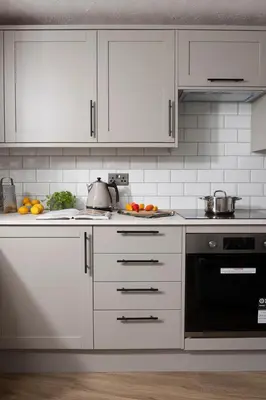 a kitchen with white cabinets and a stove top oven at City Centre 1 bed Georgian flat with courtyard in Truro
