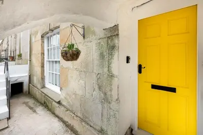 a yellow door in a hallway with a window at City Centre 1 bed Georgian flat with courtyard in Truro