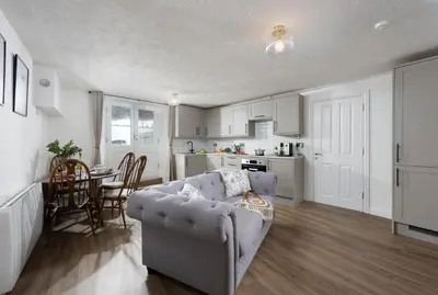a living room with a couch and a kitchen at City Centre 1 bed Georgian flat with courtyard in Truro