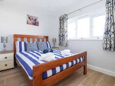 a bedroom with a bed with blue and white stripes at Atlantic Escape in Bude