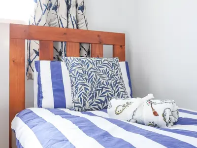 a bed with blue and white sheets and pillows at Atlantic Escape in Bude