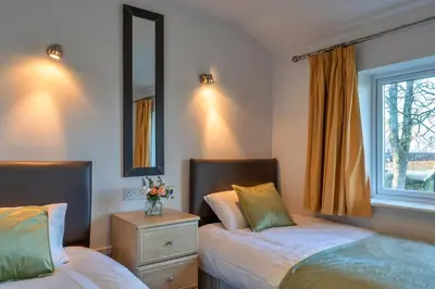 a bedroom with two beds and a window at Finest Retreats - Carworgie Cottage in Newquay