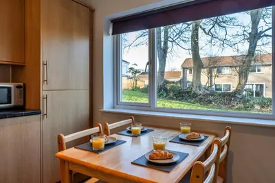 a dining room table with two plates of food and a window at Finest Retreats - Carworgie Cottage in Newquay