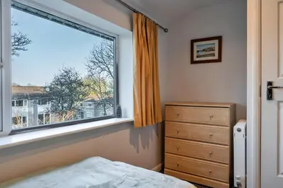 a bedroom with a large window and a dresser at Finest Retreats - Carworgie Cottage in Newquay