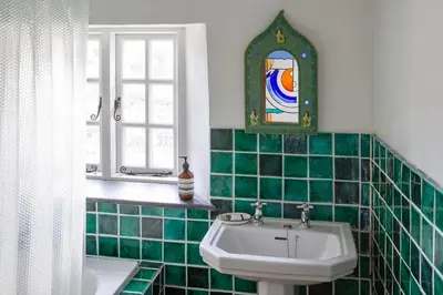 a green tiled bathroom with a sink and a window at Penkenna House - magical home and location Saturday to Saturday bookings only 7 night min July to October in Crackington Haven