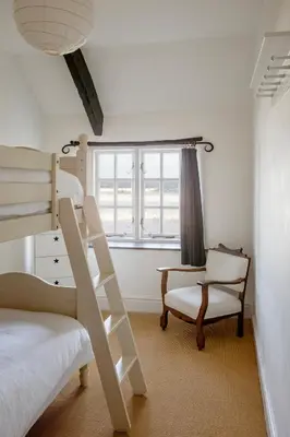 a bedroom with a bunk bed and a chair and a ladder at Penkenna House - magical home and location Saturday to Saturday bookings only 7 night min July to October in Crackington Haven