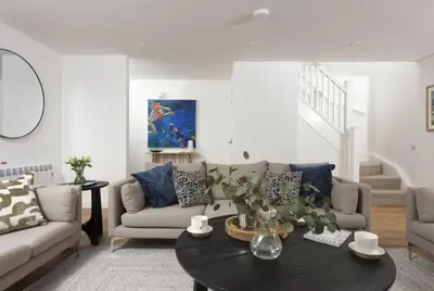a living room with a couch and a table at Carbis Bay Lodge - Spa Facilities & Woodburner in Carbis Bay