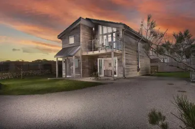 a house on a driveway in front of a sunset at Carbis Bay Lodge - Spa Facilities & Woodburner in Carbis Bay