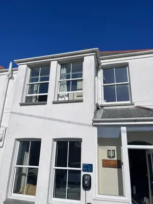 a white building with windows and a door at Trevone Holidays Kohinoor in Padstow