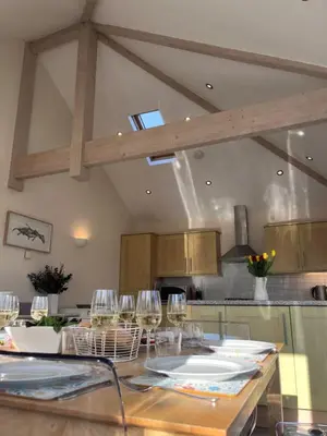 a kitchen with a table with wine glasses on it at Trevone Holidays Kohinoor in Padstow