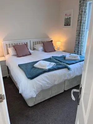 a bedroom with two beds with towels on them at Trevone Holidays Kohinoor in Padstow