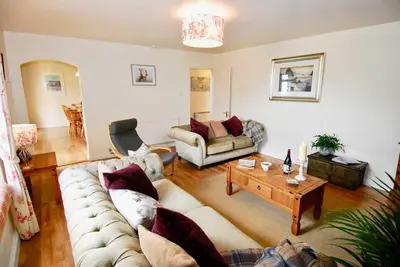 a living room with a couch and a table at Riverside farm cottage on private wildlife estate 2-bedrooms in Washaway