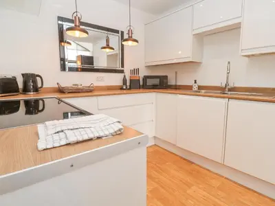 a kitchen with white cabinets and a sink at Chy Benyngoth in Hayle