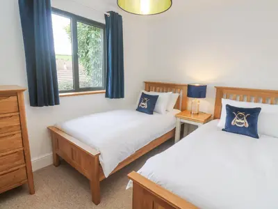 a bedroom with two beds and a window at Chy Benyngoth in Hayle