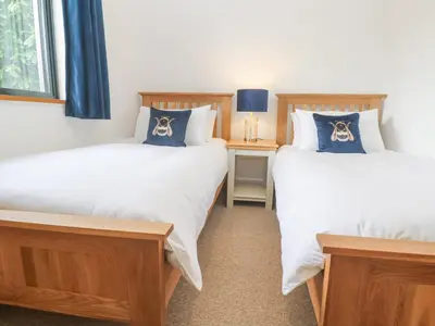 two twin beds in a room with a table at Chy Benyngoth in Hayle
