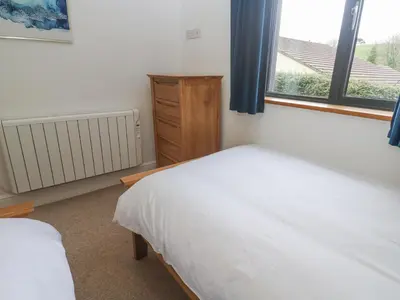 a bedroom with a white bed and a window at Chy Benyngoth in Hayle
