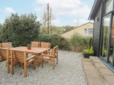 a wooden table and chairs on a gravel patio at Chy Benyngoth in Hayle