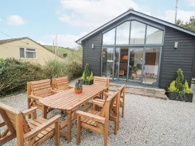 a picnic table and chairs in front of a tiny house at Chy Benyngoth in Hayle