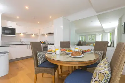 a kitchen and dining room with a table with food on it at Lowena in St Ives