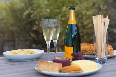 a table with a bottle of champagne and a plate of food at Lowena in St Ives