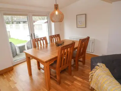 a dining room with a wooden table and chairs at Anneth Lowen in Hayle