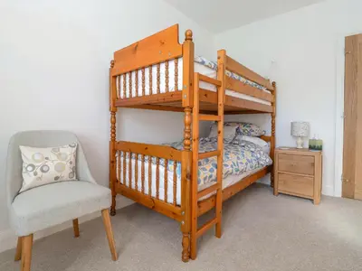 a bedroom with a bunk bed and a chair at The Haven in Marazion
