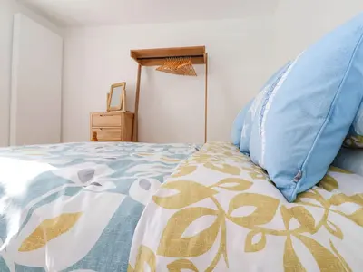 a bedroom with a bed with blue pillows on it at The Haven in Marazion