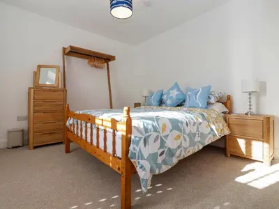 a bedroom with a bed and a dresser and a mirror at The Haven in Marazion