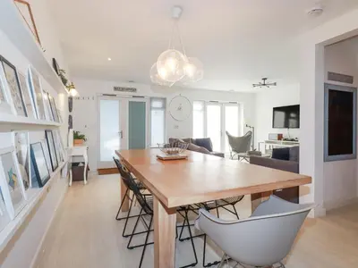 a dining room and living room with a table and chairs at Tincroft in Truro