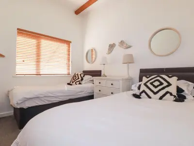 a bedroom with two beds and a mirror at Tincroft in Truro