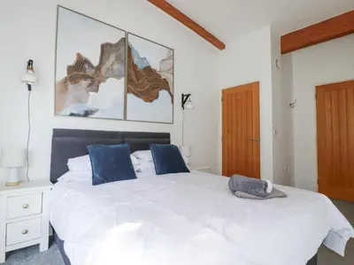 a bedroom with a large white bed with blue pillows at Tincroft in Truro