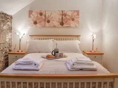 a bed with a tray of food on it at The Piggery - Uk49014 in Liskeard