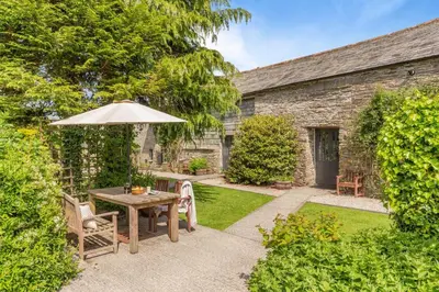 a garden with a table and an umbrella at 2 Bed in Launceston oc-f30999 in Lewannick