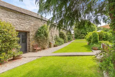a garden with green grass and a brick building at 2 Bed in Launceston oc-f30999 in Lewannick
