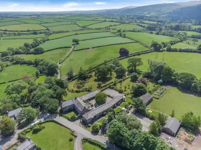 an aerial view of a field with trees and buildings at 2 Bed in Launceston oc-g31003 in Lewannick