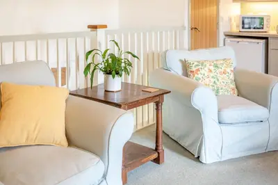 a living room with two chairs and a table at 2 Bed in Launceston oc-g31003 in Lewannick