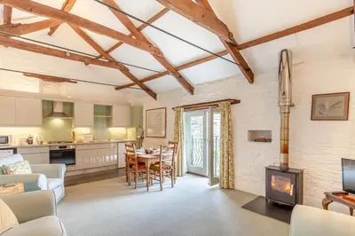 a kitchen and living room with a table and a fireplace at 2 Bed in Launceston oc-g31003 in Lewannick