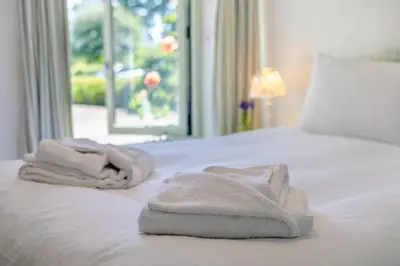 two towels on a white bed with a window at 3 Bed in Launceston oc-l31001 in Lewannick